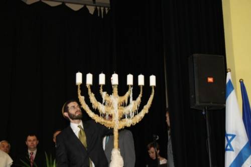  Rabin Gminy Wyznaniowej Żydowskiej Joshua Ellis odpala świecę na menorze.